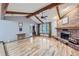 Spacious living room with hardwood floors, a brick fireplace, and wood beams at 11275 Ranch Pl, Denver, CO 80234