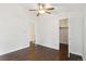 Bright bedroom featuring hardwood flooring, neutral paint, ceiling fan and open closet and bathroom doors at 8060 Niwot Rd # 38, Niwot, CO 80503