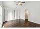 Open bedroom showcasing hardwood floors, white walls, closet space, ceiling fan, and an open door at 8060 Niwot Rd # 38, Niwot, CO 80503