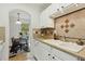 Well-lit kitchen with white cabinets and breakfast nook featuring a table with seating near a window at 8060 Niwot Rd # 38, Niwot, CO 80503