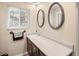 Bathroom featuring double sinks, framed mirrors, and a window with blinds at 28735 Little Big Horn Dr, Evergreen, CO 80439