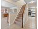 Bright entryway with tiled floors, staircase, and views into the living room and kitchen at 28735 Little Big Horn Dr, Evergreen, CO 80439