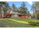 Two story house with stone facade, wood siding, large deck, and mature landscaping at 28735 Little Big Horn Dr, Evergreen, CO 80439
