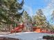 Ranch style home on a wooded lot with snow on the ground at 28735 Little Big Horn Dr, Evergreen, CO 80439