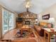 Cozy living room with a stone fireplace, wood accents, and sliding door to backyard at 28735 Little Big Horn Dr, Evergreen, CO 80439