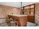A wet bar with counter seating features a stone countertop and exposed brick providing a rustic yet modern touch at 1376 S Clayton St, Denver, CO 80210