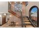 Inviting foyer with a brick accent wall, staircase, and arched window at 1376 S Clayton St, Denver, CO 80210