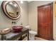 Chic half bathroom with a decorative sink, round mirror, and a wooden door at 1376 S Clayton St, Denver, CO 80210