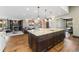 Open-concept kitchen with a granite island and a spacious living room with fireplace in the background at 1376 S Clayton St, Denver, CO 80210