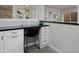 Kitchen island with seating, dark countertop and white cabinets at 1149 Columbine St # 104, Denver, CO 80206