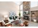 Living room with a stone fireplace, vaulted ceiling and large windows at 9053 W 103Rd Ave, Broomfield, CO 80021