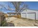 Backyard view with two car garage, wooden fence, and mature trees at 1120 Quince St, Denver, CO 80220