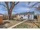 Fenced backyard features a patio, grass, a grill, and mature trees at 1120 Quince St, Denver, CO 80220