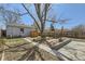The spacious backyard features a wooden fence, a stone patio, and mature trees at 1120 Quince St, Denver, CO 80220