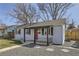 Exterior shot of the home showing a red front door, dark shutters and gray gravel front yard at 1120 Quince St, Denver, CO 80220