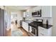 Modern kitchen featuring white cabinets, stainless steel appliances, and dark countertops at 1120 Quince St, Denver, CO 80220