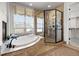 Luxurious bathroom with soaking tub, tiled shower, and walk-in closet at 9586 Silent Hills Ln, Lone Tree, CO 80124