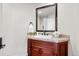 Charming bathroom vanity with granite countertop, undermount sink, framed mirror, and dark wood cabinetry at 9586 Silent Hills Ln, Lone Tree, CO 80124