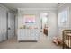 Bright bedroom boasts a white dresser, plush carpet, and ensuite bathroom access at 9586 Silent Hills Ln, Lone Tree, CO 80124