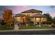 Beautifully landscaped home exterior with brick and stucco finishes at dusk at 9586 Silent Hills Ln, Lone Tree, CO 80124