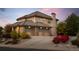 Luxurious home exterior with three-car garage, lush landscaping, and a paved driveway at 9586 Silent Hills Ln, Lone Tree, CO 80124