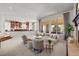 Bright living room featuring large windows, neutral tones, comfortable seating and seamless connection to the kitchen at 9586 Silent Hills Ln, Lone Tree, CO 80124