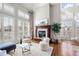 Bright living room featuring large windows, hardwood flooring, and a cozy fireplace at 9586 Silent Hills Ln, Lone Tree, CO 80124