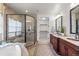 Luxurious bathroom with dual vanities, glass shower, soaking tub, and walk-in closet at 9586 Silent Hills Ln, Lone Tree, CO 80124
