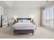 Bright main bedroom with a large bed, stylish bench, ample natural light, and neutral colored walls at 9586 Silent Hills Ln, Lone Tree, CO 80124