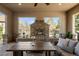 Relaxing outdoor patio with brick fireplace, comfortable sofa, and serene views of the backyard at 9586 Silent Hills Ln, Lone Tree, CO 80124