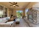 Spacious covered patio with stone fireplace, ample seating, and lush backyard access at 9586 Silent Hills Ln, Lone Tree, CO 80124