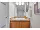 Bathroom featuring framed mirror above a sink and a light wood vanity and granite countertops at 3571 S Kittredge St # C, Aurora, CO 80013