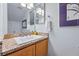 Bathroom vanity with a granite counter, a sink and framed mirror and natural wood cabinets at 3571 S Kittredge St # C, Aurora, CO 80013