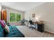 Bedroom with neutral carpet, a window with a leafy view, and a turquoise futon at 3571 S Kittredge St # C, Aurora, CO 80013
