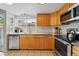 A bright kitchen with wood cabinets, granite counters, tile flooring, and stainless appliances at 3571 S Kittredge St # C, Aurora, CO 80013