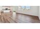 Sunlit living room with hardwood floors, next to the kitchen with a kitchen island at 1671 Pinnacle Ave, Lochbuie, CO 80603