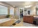 Bright bathroom with a soaking tub, walk-in shower, and vanity with ample counter space at 2015 E 167Th Ln, Thornton, CO 80602