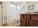 Bright bathroom with a shower-tub combo, brown vanity, and framed artwork at 2015 E 167Th Ln, Thornton, CO 80602