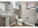 Charming powder room with pedestal sink, grey walls and wood floor at 2015 E 167Th Ln, Thornton, CO 80602