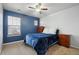 Cozy bedroom with a blue accent wall, plush carpeting, and natural light at 2015 E 167Th Ln, Thornton, CO 80602