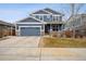 Charming blue two-story home with a covered front porch and well-maintained lawn at 2015 E 167Th Ln, Thornton, CO 80602