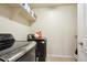 Well-lit laundry room with modern black washer and dryer and ample shelf space at 2015 E 167Th Ln, Thornton, CO 80602