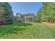 Lush green backyard with a covered patio, mature trees, and well-maintained lawn at 10421 Kennemere Ln, Parker, CO 80134