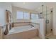 Bright bathroom featuring a soaking tub and separate glass shower with tiled accents and modern fixtures at 10421 Kennemere Ln, Parker, CO 80134