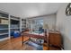 Functional home office with built-in bookshelves, wood desk, and natural light from the window at 10421 Kennemere Ln, Parker, CO 80134