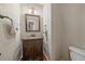 Charming powder room features a dark wood vanity, marble countertop, mirror, and elegant fixtures at 10421 Kennemere Ln, Parker, CO 80134
