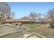 Large backyard featuring a shed, patio area, fire pit, and mature trees at 6661 Lamar St, Arvada, CO 80003