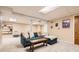 Basement living area with neutral carpet, a comfortable sofa, and built-in shelving at 6661 Lamar St, Arvada, CO 80003