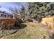 Spacious backyard featuring a deck, lush greenery, and a wooden fence for privacy at 7220 S Lewis St, Littleton, CO 80127