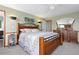 Main bedroom featuring warm wood tones, plush carpet, and plenty of natural light at 7220 S Lewis St, Littleton, CO 80127